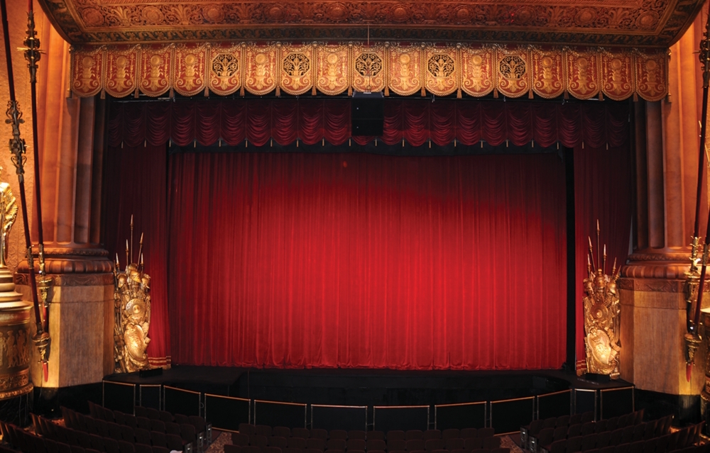 Red theater curtains for sale installed on stage with red grand drapes, valance, and proscenium arch